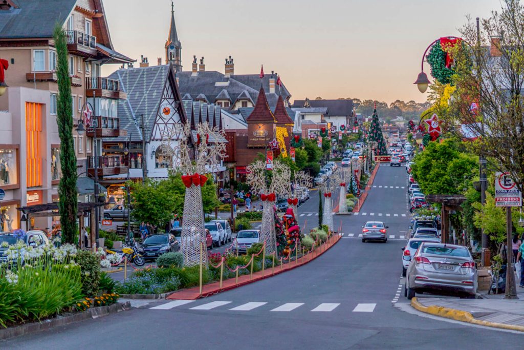 Imagem durante a tarde, com a principal rua de Gramado decorada com enfeites de Natal